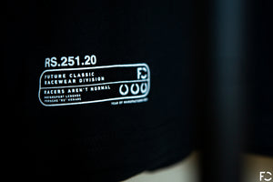 Close up view of black Future Classic t-shirt frontside with printed homologation tag