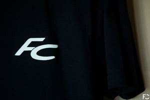 Close up view of black Future Classic t-shirt frontside with white FC logo text
